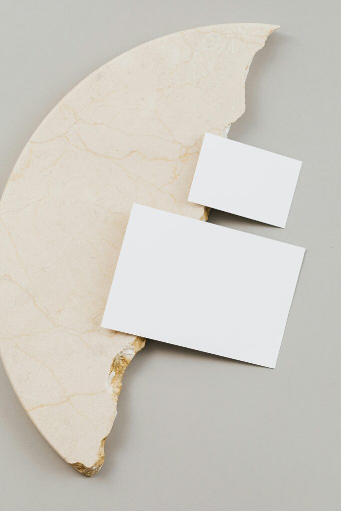Flat lay of white cards on a marble surface, ideal for modern minimalist design.